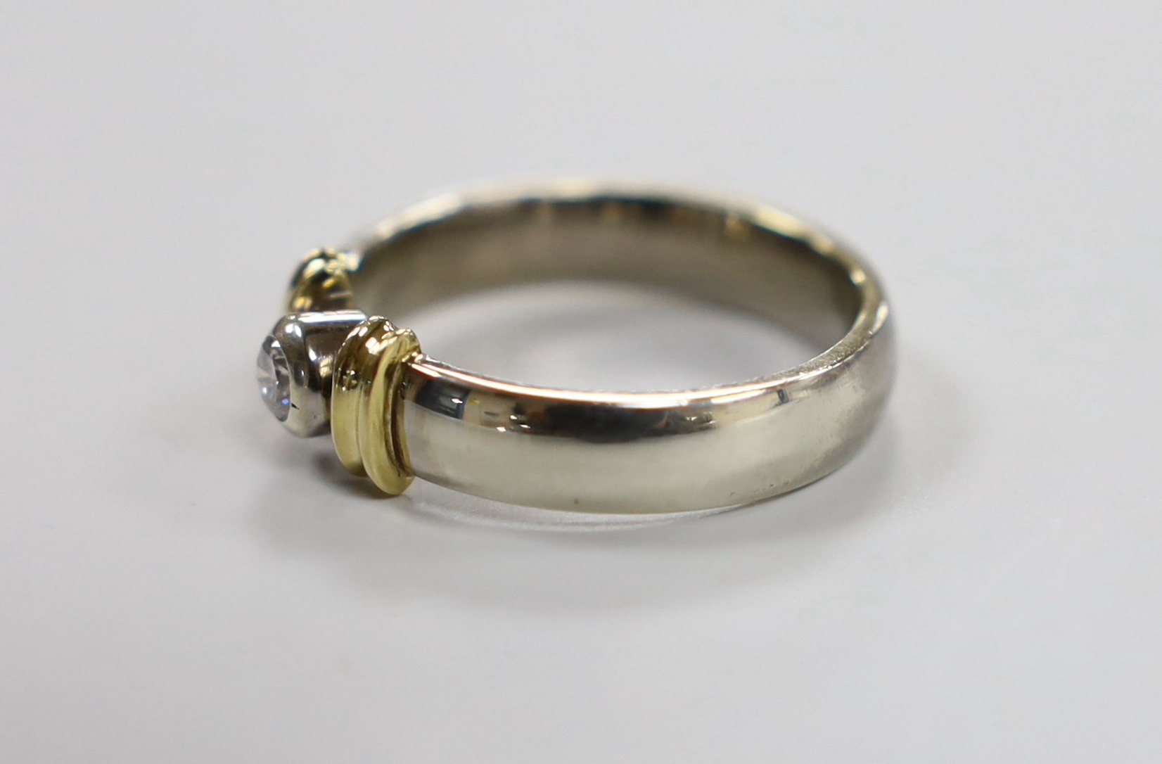 A modern two colour 9ct gold and single stone diamond set ring, size V/W, gross weight 9.1 grams.
